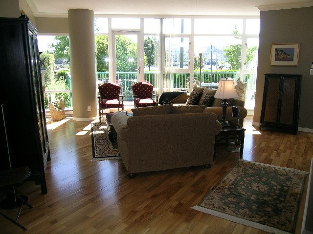 Spacious living room with hardwood floors, large windows, and a cozy seating area. - 1035 Marinaside Crescent, Vancouver Downtown