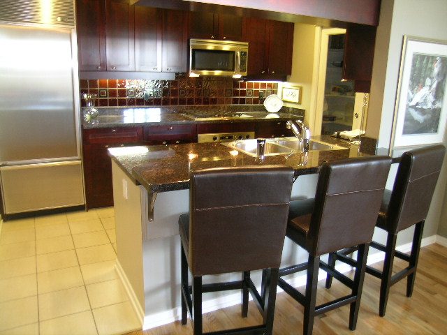 Modern kitchen with granite countertops, stainless steel appliances, and hardwood floors. - 1035 Marinaside Crescent, Vancouver Downtown