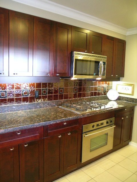 Modern kitchen with granite countertops and dark wood cabinets, perfect for a cozy downtown townhouse. - 1035 Marinaside Crescent, Vancouver Downtown