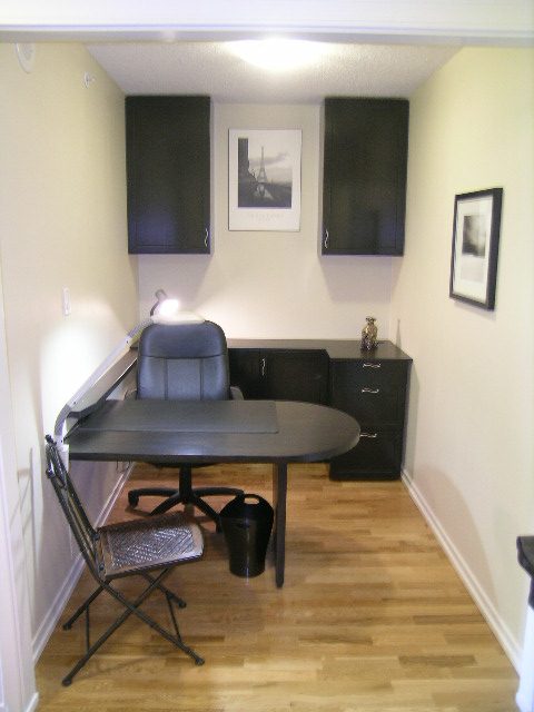 Spacious office with black cabinets, hardwood floors, and a desk setup. - 1035 Marinaside Crescent, Vancouver Downtown