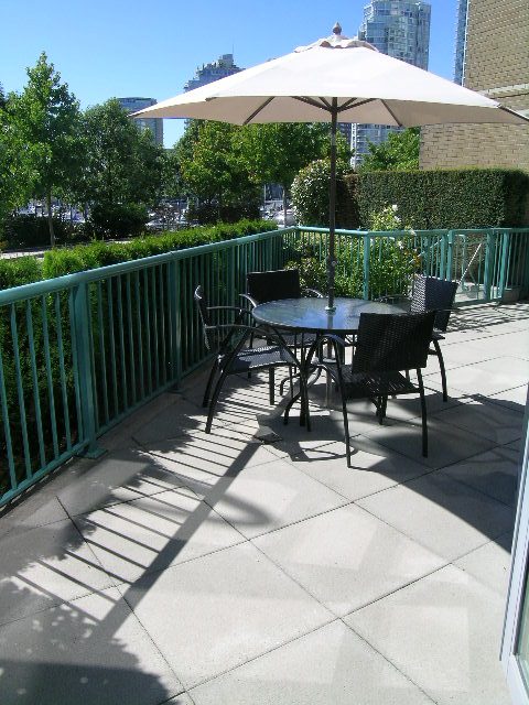 Furnished patio with umbrella, seating, and city view at 1035 Marinaside Crescent, Vancouver Downtown. - 1035 Marinaside Crescent, Vancouver Downtown