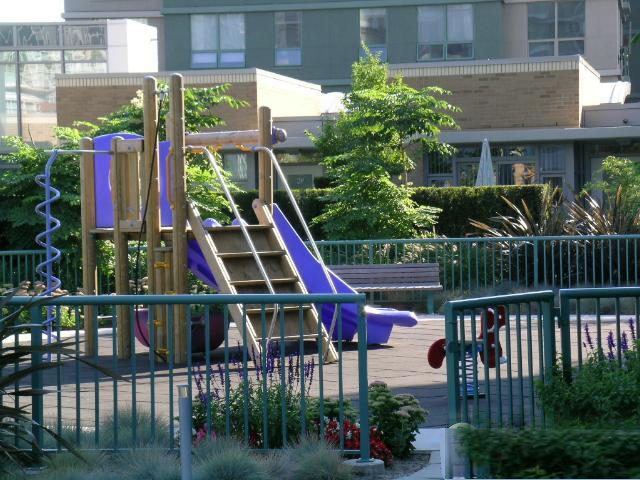 Spacious outdoor play area with colorful equipment and lush greenery. - 1035 Marinaside Crescent, Vancouver Downtown