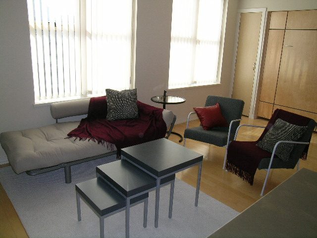 Bright living room with modern furniture, hardwood floors, and large windows. - 409 - 969 Richards Street, Vancouver Downtown