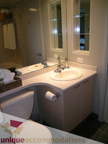 Furnished bathroom with dual sinks, mirrored cabinets, and a toilet. - 707 - 1068 Hornby Street, Vancouver Downtown