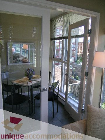 Bright dining area with large windows, city view, and modern decor. - 707 - 1068 Hornby Street, Vancouver Downtown