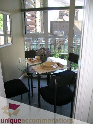 Bright dining area with glass table, black chairs, and city view. - 707 - 1068 Hornby Street, Vancouver Downtown