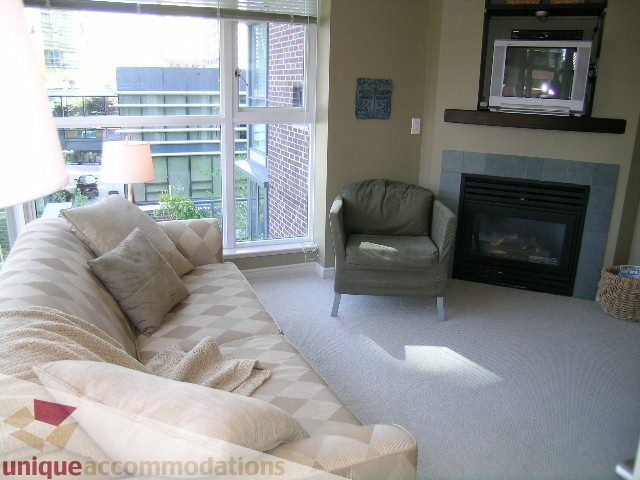 Furnished living room with large windows, city view, and cozy seating. - 707 - 1068 Hornby Street, Vancouver Downtown
