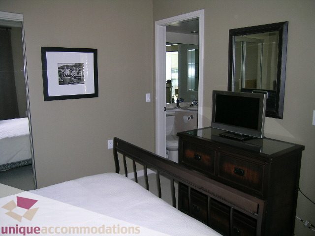 Furnished 1-bedroom condo with dark wood dresser, countertop, and framed artwork. - 707 - 1068 Hornby Street, Vancouver Downtown