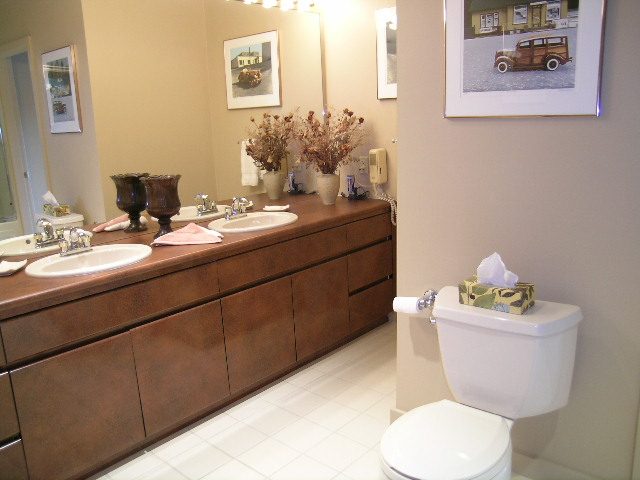 Furnished bathroom with wooden cabinets and white tile floor. - 4527 Stonehaven Avenue, North Vancouver