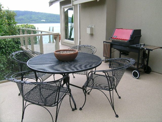 Furnished patio with outdoor furniture and a BBQ grill, overlooking a scenic view. - 4527 Stonehaven Avenue, North Vancouver