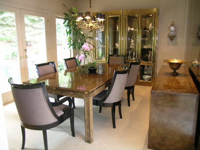 Elegant dining room with a wooden table, upholstered chairs, and a glass china cabinet. - 4527 Stonehaven Avenue, North Vancouver