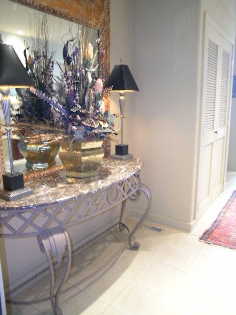 Foyer with elegant console table, black lamps, and decorative floral arrangement. - 4527 Stonehaven Avenue, North Vancouver