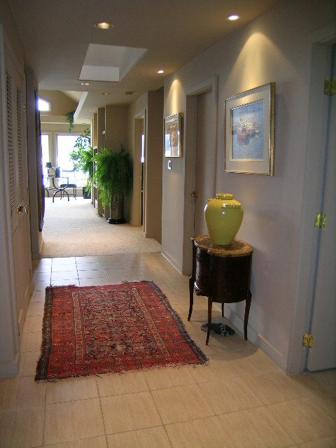 Foyer with tiled floor, red rug, and framed art. - 4527 Stonehaven Avenue, North Vancouver