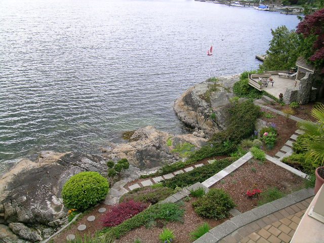 Bright waterfront living room with a view of the ocean and a sailboat. - 4527 Stonehaven Avenue, North Vancouver
