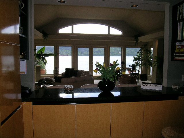 Bright living room with large windows, city view, and modern furnishings. - 4527 Stonehaven Avenue, North Vancouver