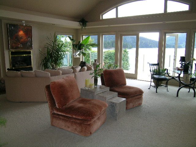 Spacious living room with large windows, lake view, and comfortable furniture. - 4527 Stonehaven Avenue, North Vancouver