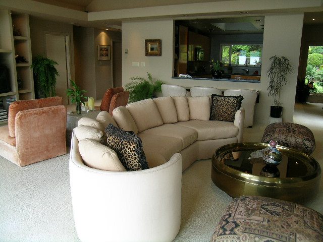 Spacious living room with plush sofas, modern decor, and a view of the kitchen. - 4527 Stonehaven Avenue, North Vancouver