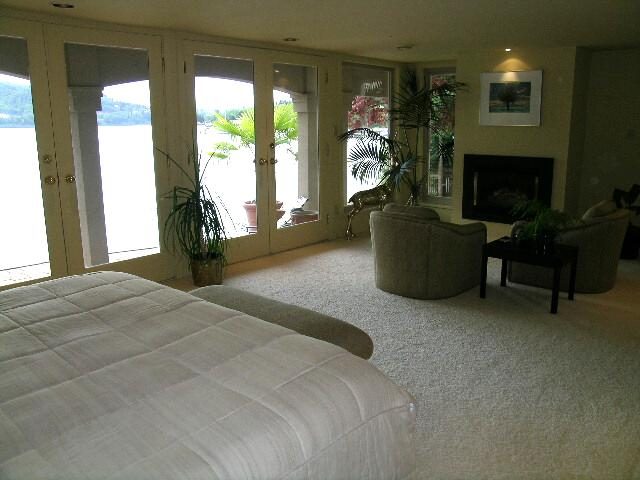Spacious living room with large windows, view of water, and cozy seating. - 4527 Stonehaven Avenue, North Vancouver