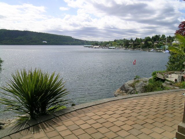 Bright patio overlooking tranquil water and lush greenery. - 4527 Stonehaven Avenue, North Vancouver