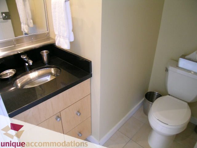 Bright bathroom with black countertops and a white toilet. - 1808 - 1003 Burnaby Street, Vancouver Downtown