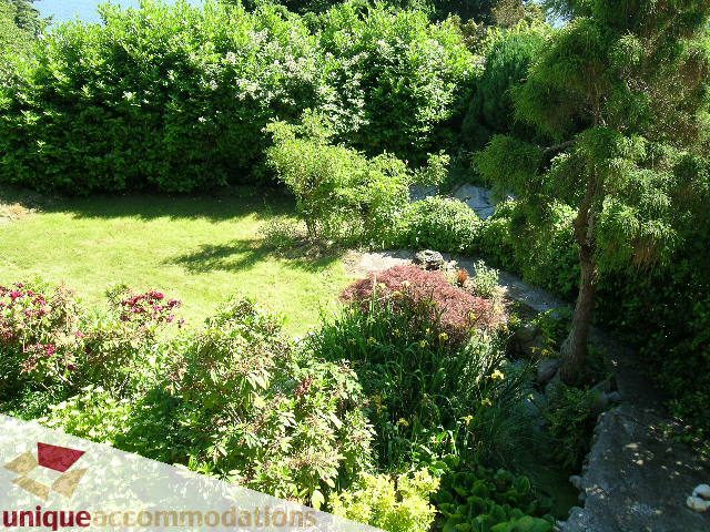 Furnished garden with lush greenery and vibrant flowers. - 3664 Creery Ave., West Vancouver