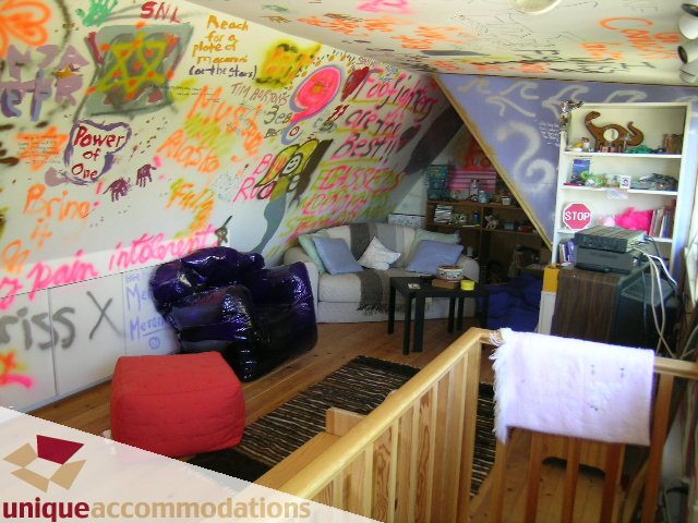 Framed living area with graffiti-covered walls and wooden floors. - 3664 Creery Ave., West Vancouver