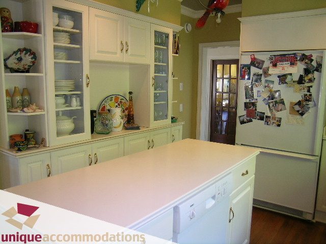 Bright kitchen with white cabinets, granite countertops, and hardwood floors. - 3664 Creery Ave., West Vancouver