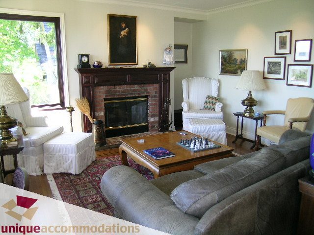 Furnished living room with a fireplace, chess set, and framed artwork. - 3664 Creery Ave., West Vancouver