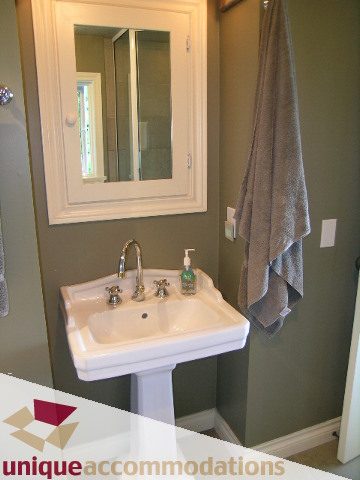 Bright bathroom with white pedestal sink, countertop, and towel rack. - 3664 Creery Ave., West Vancouver