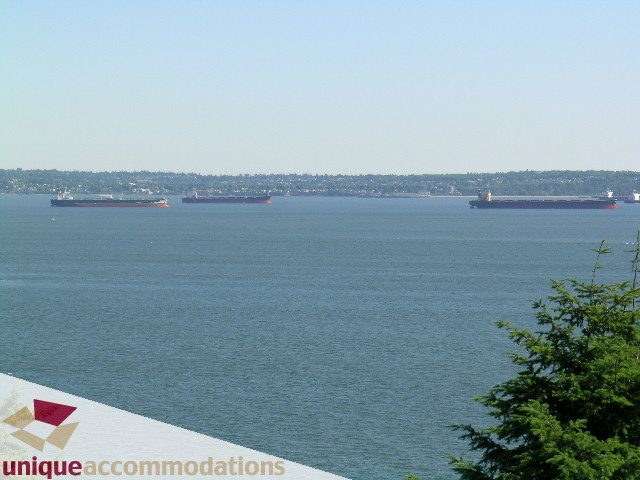 Furnished living room with a stunning city view of cargo ships on the water. - 3664 Creery Ave., West Vancouver