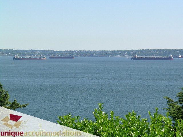 Furnished living room with a stunning city view of cargo ships on the water. - 3664 Creery Ave., West Vancouver