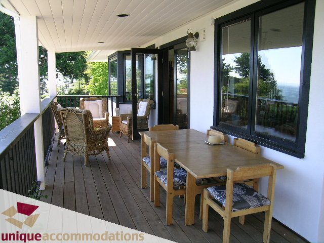 Furnished patio with wooden furniture and scenic view. - 3664 Creery Ave., West Vancouver