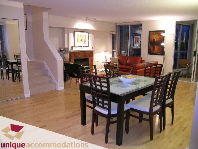 Furnished dining and living area with hardwood floors, city view, and modern decor. - 322 - 1228 Marinaside Crescent, Vancouver Downtown