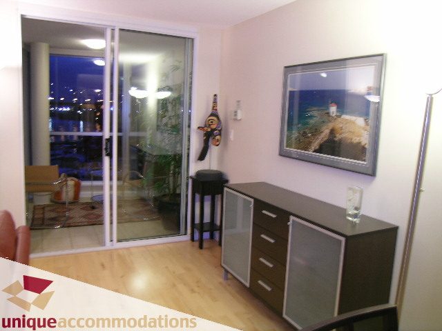 Bright living room with hardwood floors, city view, and modern furnishings. - 322 - 1228 Marinaside Crescent, Vancouver Downtown