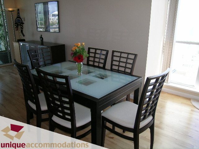Furnished dining area with glass table, black chairs, and city view. - 322 - 1228 Marinaside Crescent, Vancouver Downtown