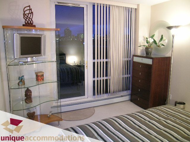 Furnished bedroom with city view and modern decor. - 322 - 1228 Marinaside Crescent, Vancouver Downtown