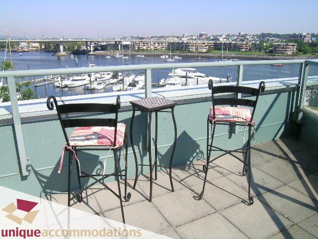 Furnished balcony with table and chairs, overlooking marina and cityscape. - 322 - 1228 Marinaside Crescent, Vancouver Downtown