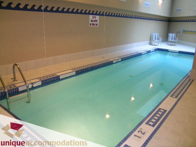 Spacious indoor pool with tiled edges and lounge chairs. - 322 - 1228 Marinaside Crescent, Vancouver Downtown