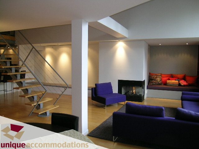 Furnished living room with purple sofas, hardwood floors, and modern lighting. - 401 - 2525 Quebec Street, Vancouver East Side