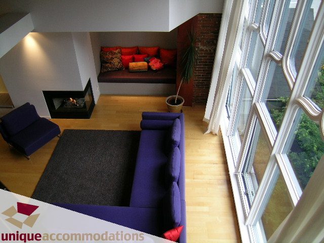 Bright living room with hardwood floors, city view, and modern furniture. - 401 - 2525 Quebec Street, Vancouver East Side