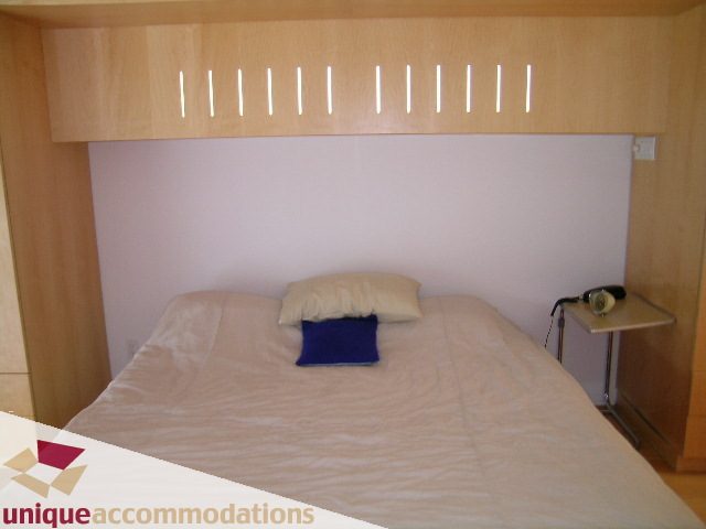 Bright, modern bedroom with a unique headboard and bedside table. - 401 - 2525 Quebec Street, Vancouver East Side