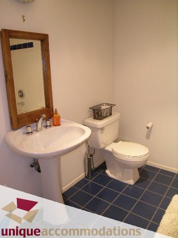 Bathroom with blue tile floor, white sink, and toilet. - 401 - 2525 Quebec Street, Vancouver East Side