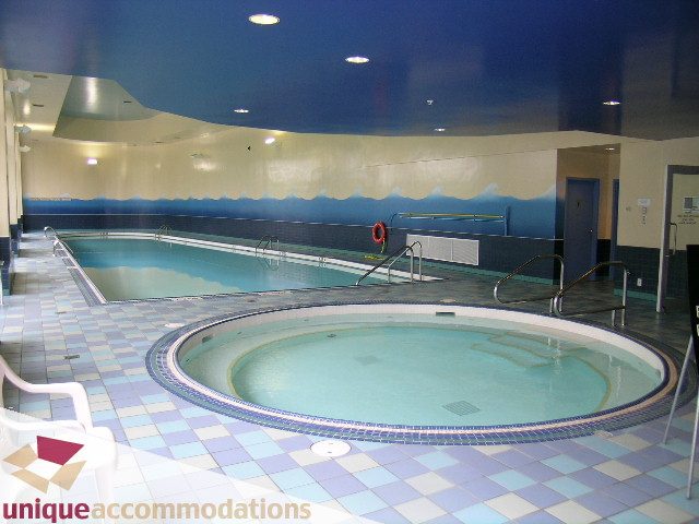 Spacious, modern indoor pool area with tiled floors and blue accents. - 2502 - 1077 Marinaside Crescent, Vancouver Downtown