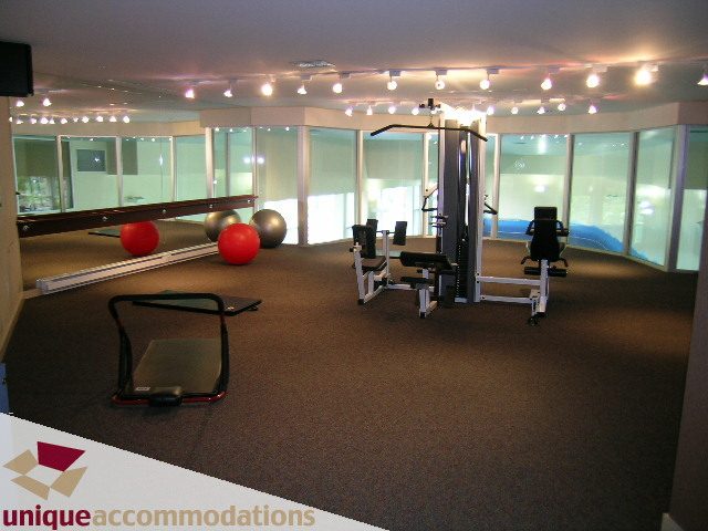 Bright fitness room with exercise equipment and large windows, offering a view of the city. - 2502 - 1077 Marinaside Crescent, Vancouver Downtown