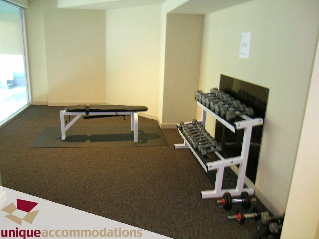 Bright gym with weight rack and exercise bench. - 2502 - 1077 Marinaside Crescent, Vancouver Downtown