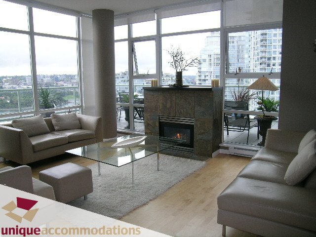 Bright living room with city view, modern furniture, hardwood floors, and a fireplace. - 2502 - 1077 Marinaside Crescent, Vancouver Downtown