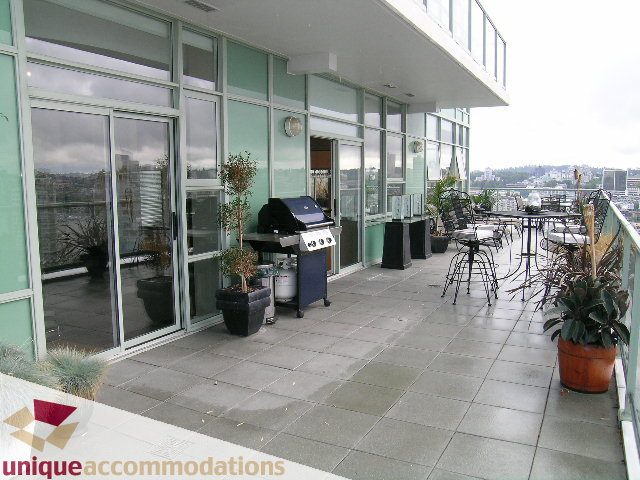 Furnished rooftop patio with outdoor seating, BBQ, and city view. - 2502 - 1077 Marinaside Crescent, Vancouver Downtown