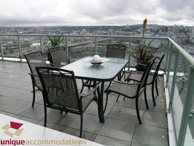 Furnished patio with glass table, chairs, and city view. - 2502 - 1077 Marinaside Crescent, Vancouver Downtown