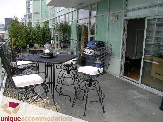 Furnished patio with outdoor seating, grill, and modern decor. - 2502 - 1077 Marinaside Crescent, Vancouver Downtown