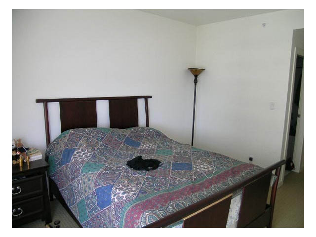 Spacious bedroom with a large bed, patterned bedding, and a tall floor lamp. - 1703 - 1005 Beach Avenue, Vancouver Downtown